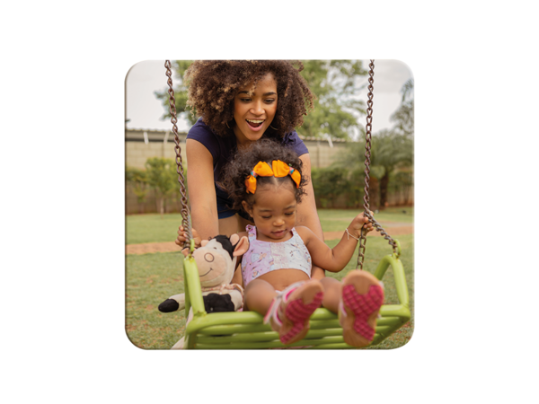 Quadratischer Magnetsticker ca. 5,8 x 5,8 cm zeigt Mutter mit Kind auf Schaukel, die Mutter schubst das Kind sanft an.